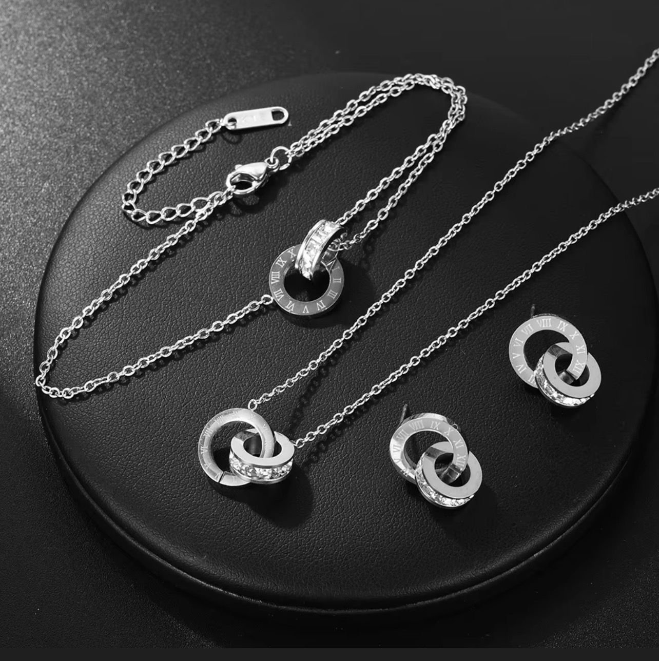 Titanium silver steel Roman numeral double-loop jewelry set including a necklace, bracelet, and earrings