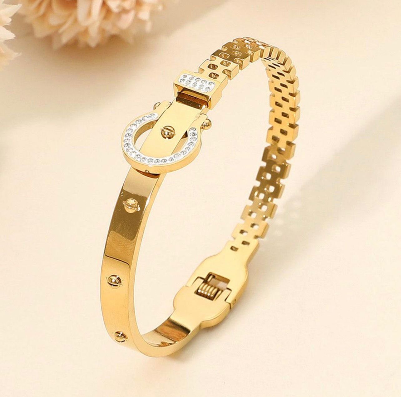 18K Gold-Plated bangle features a rhinestone-encrusted buckle clasp and a textured band