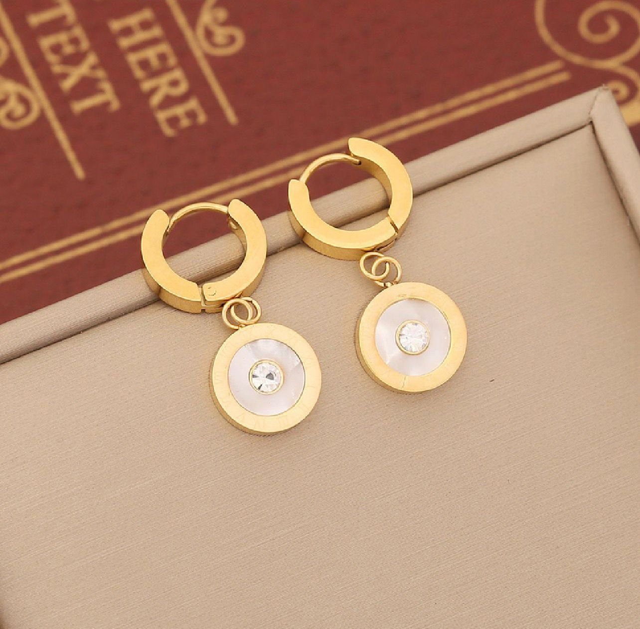 18K gold-plated hoop earrings with a circular pendant and a central sparkling stone