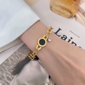 18K Gold-Plated bracelet featuring round charm with black inlay and Roman numerals, and a dangling zircon stone
