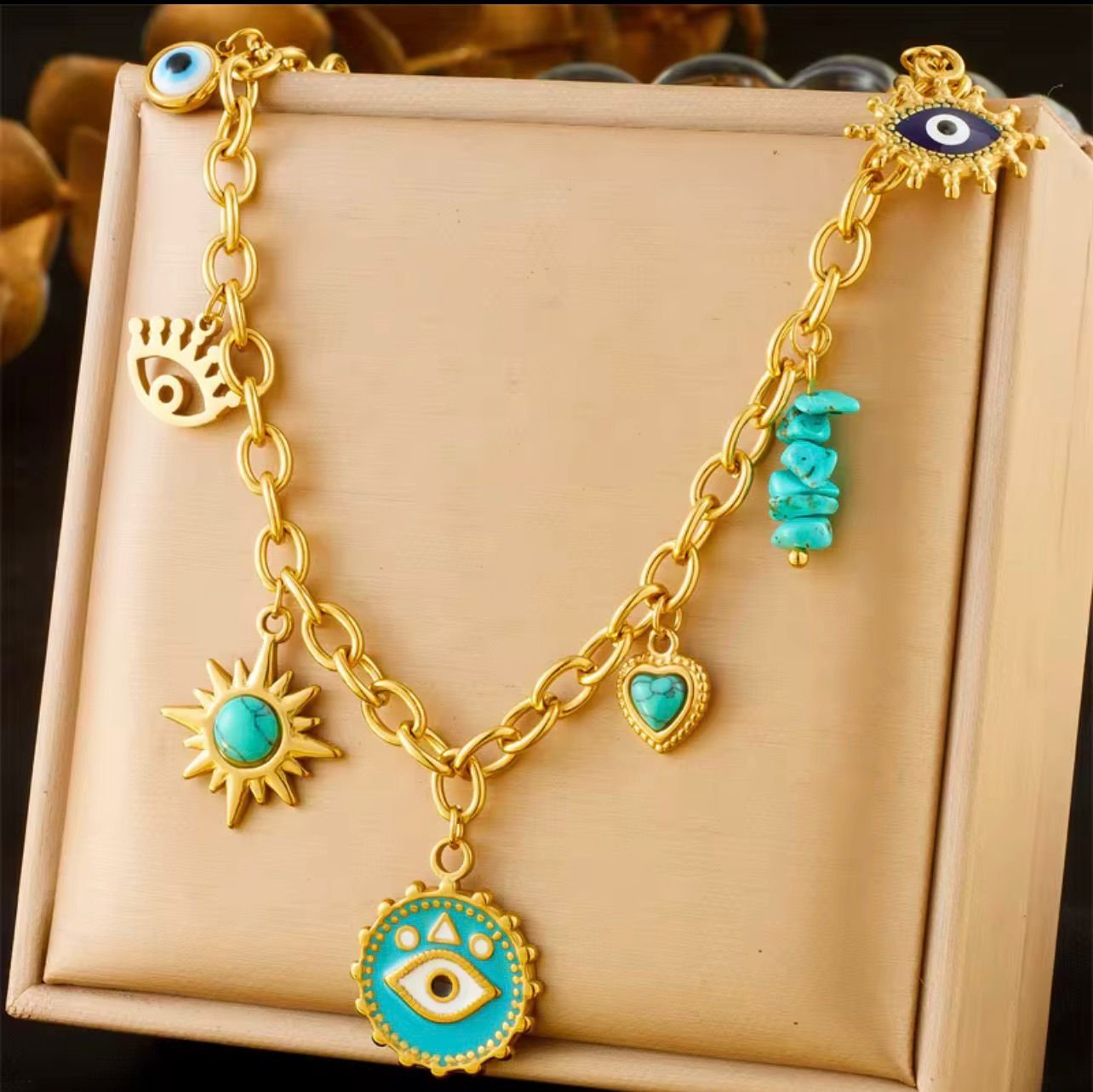 18K Gold Plated necklace with turquoise evil eye pendant and multiple charms including turquoise-colored hearts and sunbursts