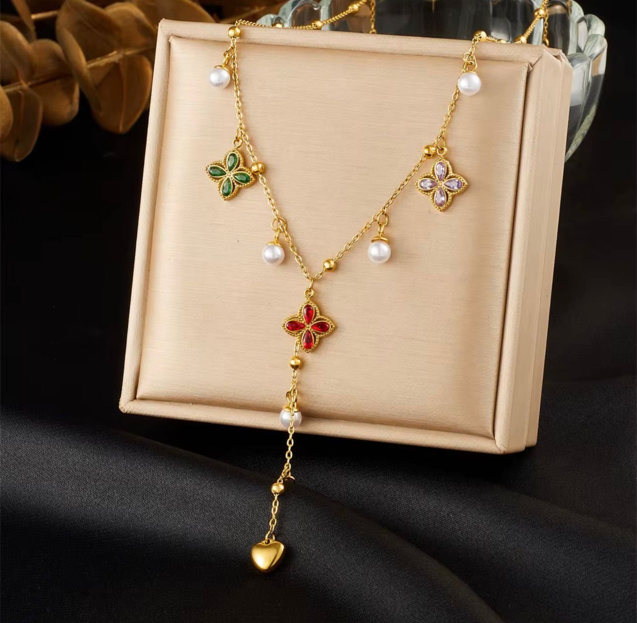 18K Gold-Plated necklace features a delicate chain adorned with colorful clover motifs and pearl accents