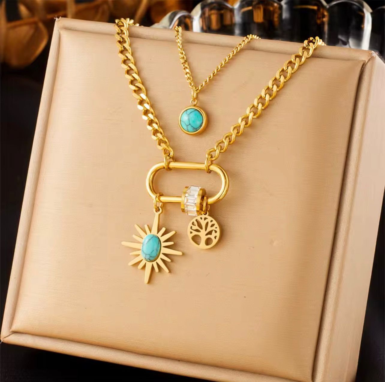 18K Gold-Plated double layer necklace featuring turquoise accents, a radiant sunburst charm, a Zircon-studded hoop, and a tree-of-life pendant