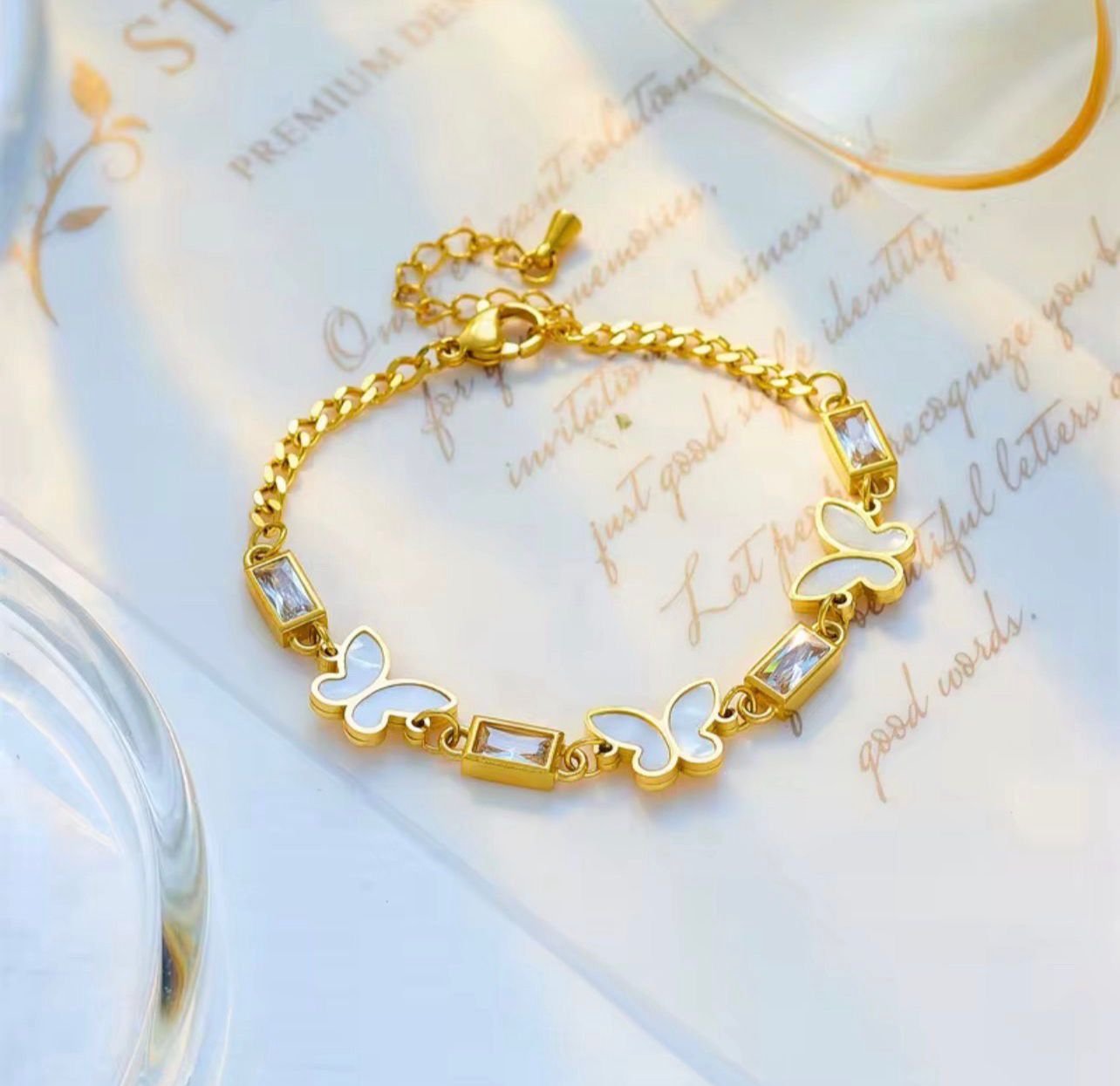 18K Gold-Plated butterfly bracelet featuring white shell butterflies, and baguette cubic zirconia stones
